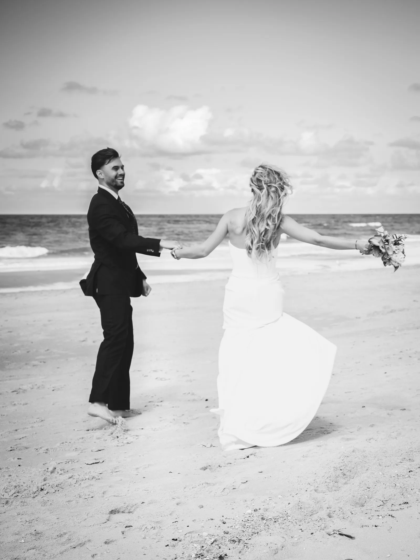 Hochzeitsfotografie Sylt — Brautpaar tanzt barfuß am Strand